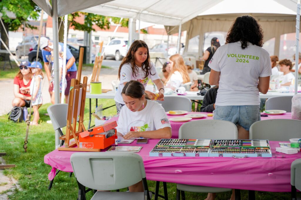 Two young people in white t-shirts doing art activities. 